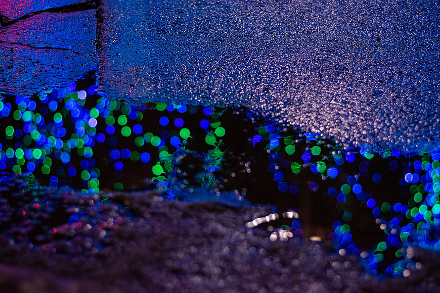 Abstract Blue and Green Bokeh Lights on Wet Pavement