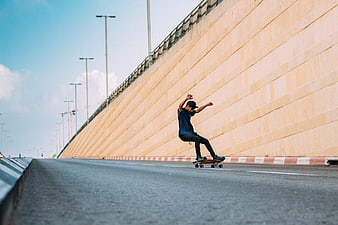 Skateboarder performing trick on empty highway road