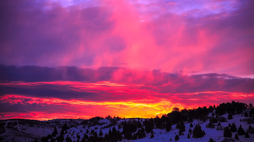 Vibrant Pink Winter Sunset Over Snowy Mountain Landscape