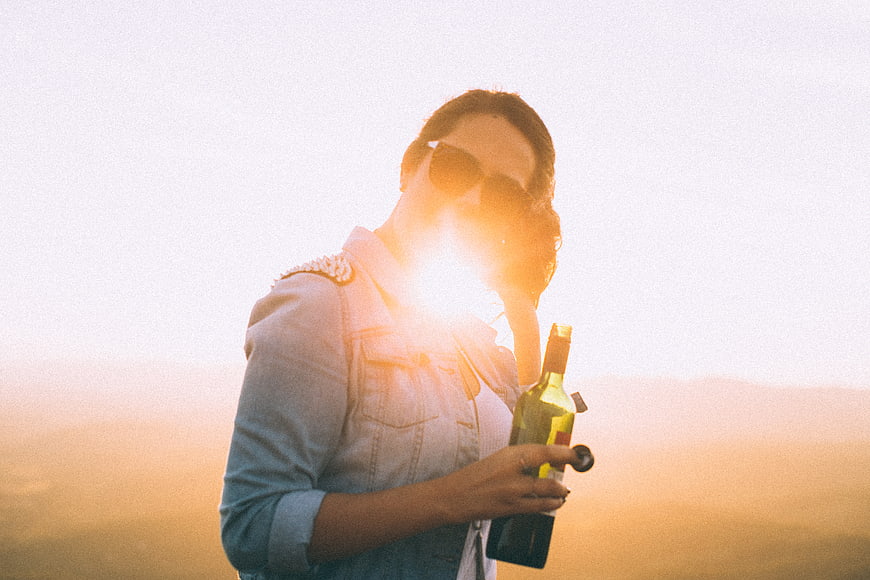 Woman with Wine Bottle in Golden Hour Sunlight