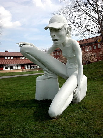 White Sculpture of Woman in Cap on Green Lawn