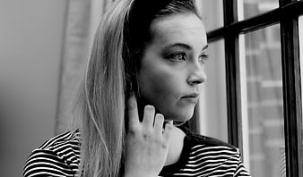 Black and white portrait of woman looking out window