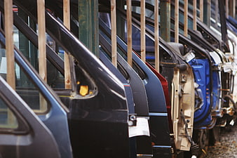 Row of car doors hanging on rack in auto parts warehouse