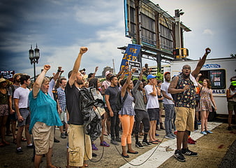 Diverse crowd protesting with raised fists and signs