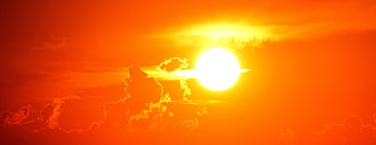 Vibrant Orange Sunset with Bright Sun and Clouds