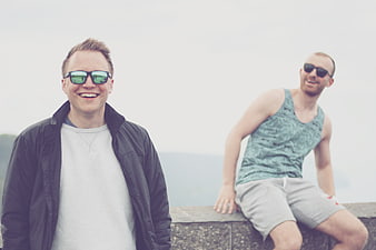 Two Happy Men Wearing Sunglasses Smiling Outdoors