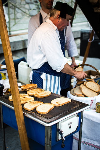 Traditional Czech garlic bread being toasted at a street market