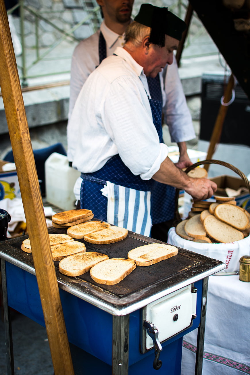 Traditional Czech garlic bread being toasted at a street market