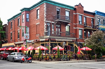 Outdoor dining at a corner restaurant in a brick building