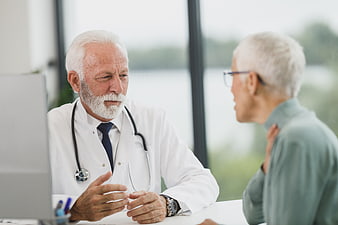 Senior Doctor Consulting with Elderly Patient in Clinic