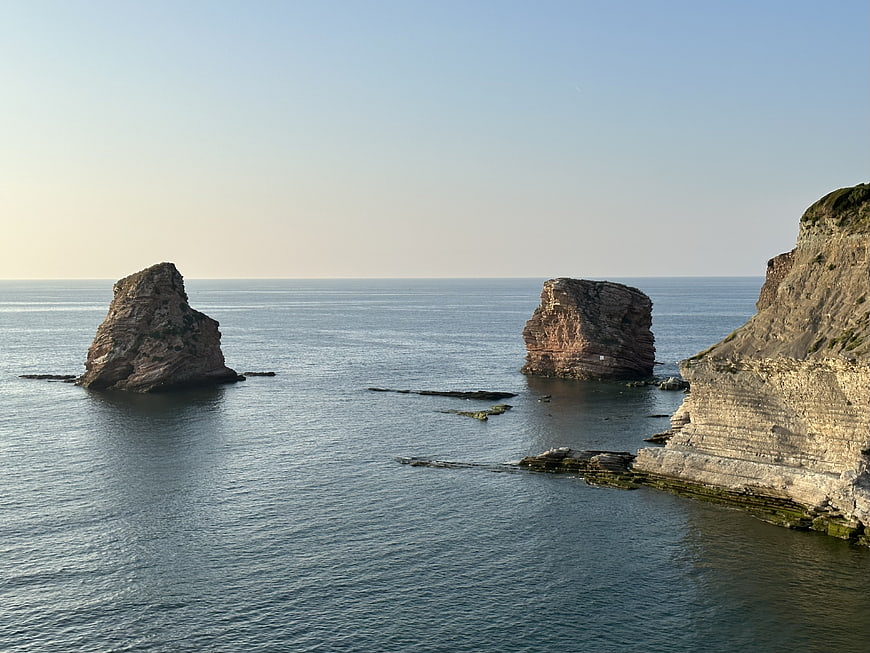 Serene coastal landscape with sea stacks and cliffs at sunset