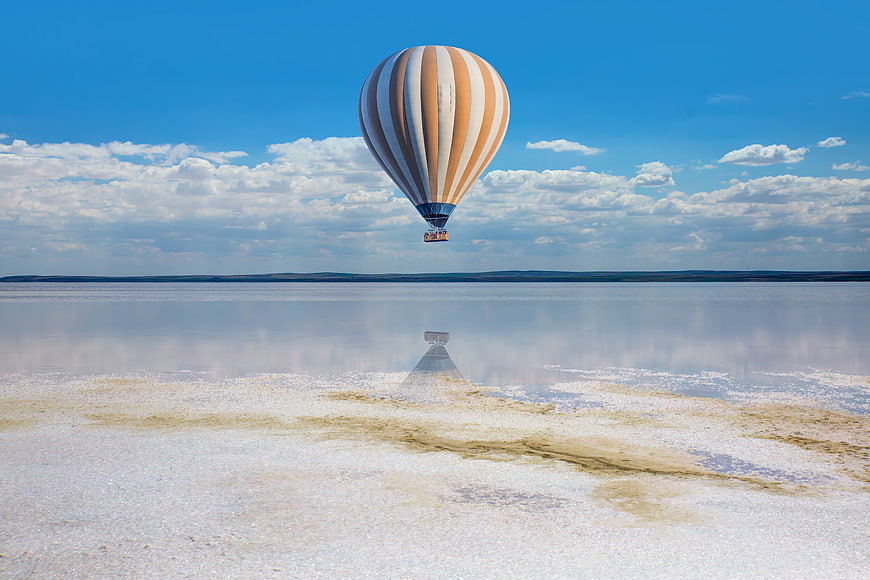 Hot Air Balloon Flying Over Salt Lake Reflection