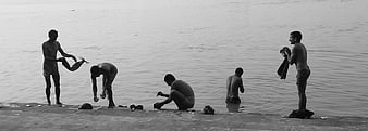 Men bathing and washing clothes in a river
