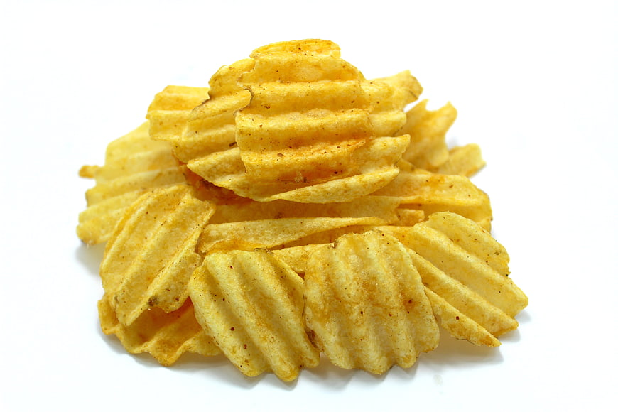 Pile of Crispy Crinkle-Cut Potato Chips on White Background