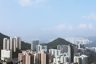 Dense Urban Skyline with High-Rise Buildings and Green Hills