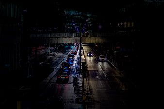 Night traffic on wet city road under overpass