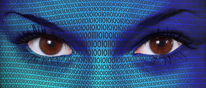 Close-up of human eyes with blue binary code overlay