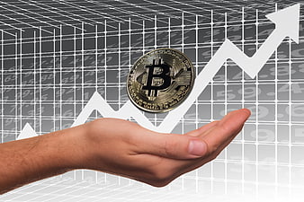Hand holding Bitcoin coin over rising financial chart background