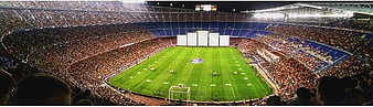 Wide panoramic view of a packed football stadium at night
