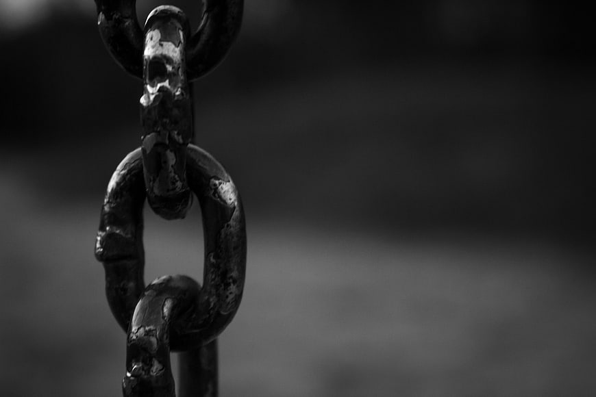 Close-up of rusty metal chain links in black and white