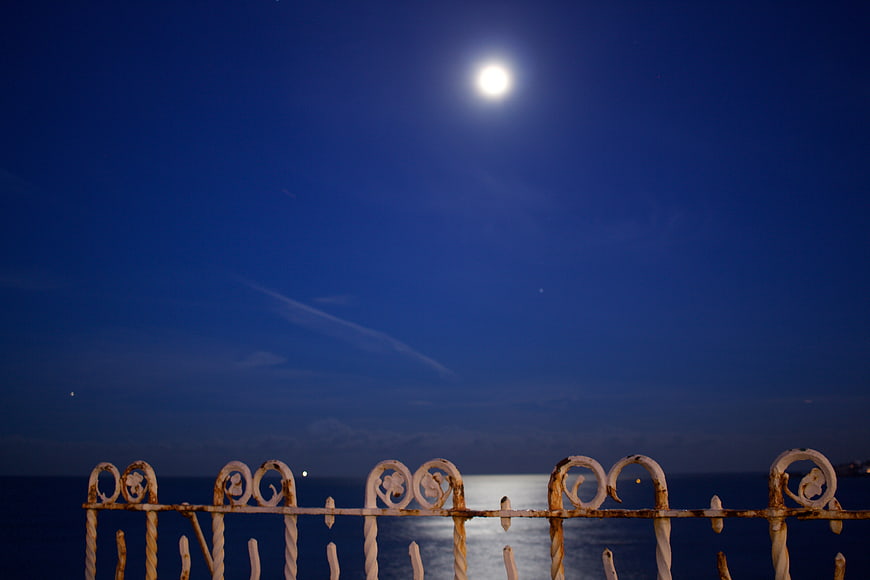 Full Moon Over Ocean with Rusty Balcony Railing