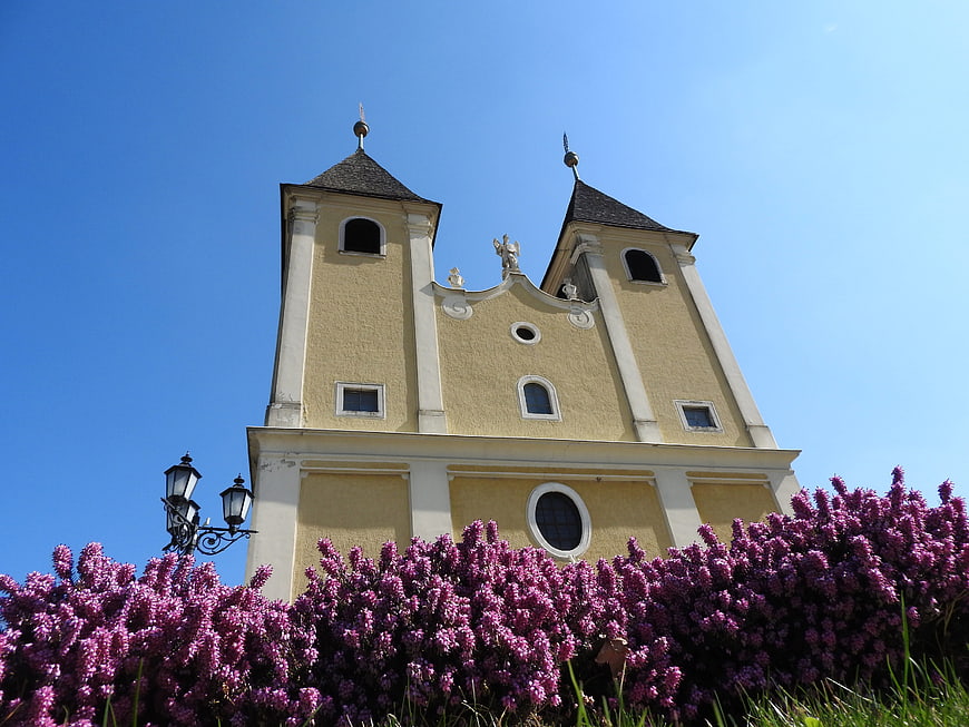 Yellow Baroque Church with Purple Lilacs and Blue Sky