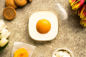 Creative egg-shaped cake with peach yolk and spring tulips