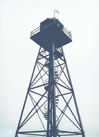 Low angle view of metal guard tower against overcast sky