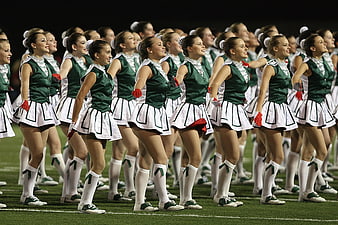 Cheerleaders in Green and White Uniforms on Football Field