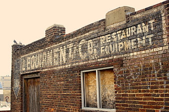 Vintage Ghost Sign on Weathered Brick Wall