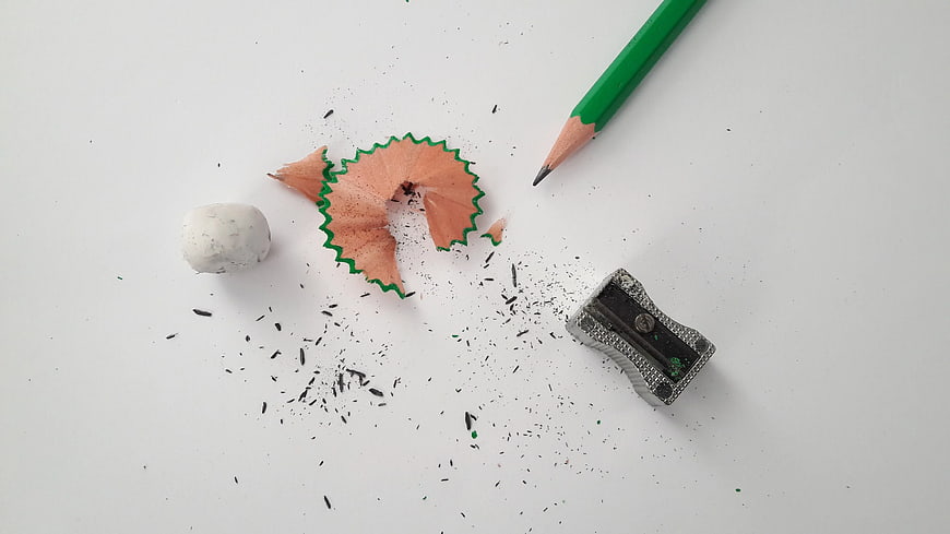 Green Pencil, Sharpener, and Shavings on White Background