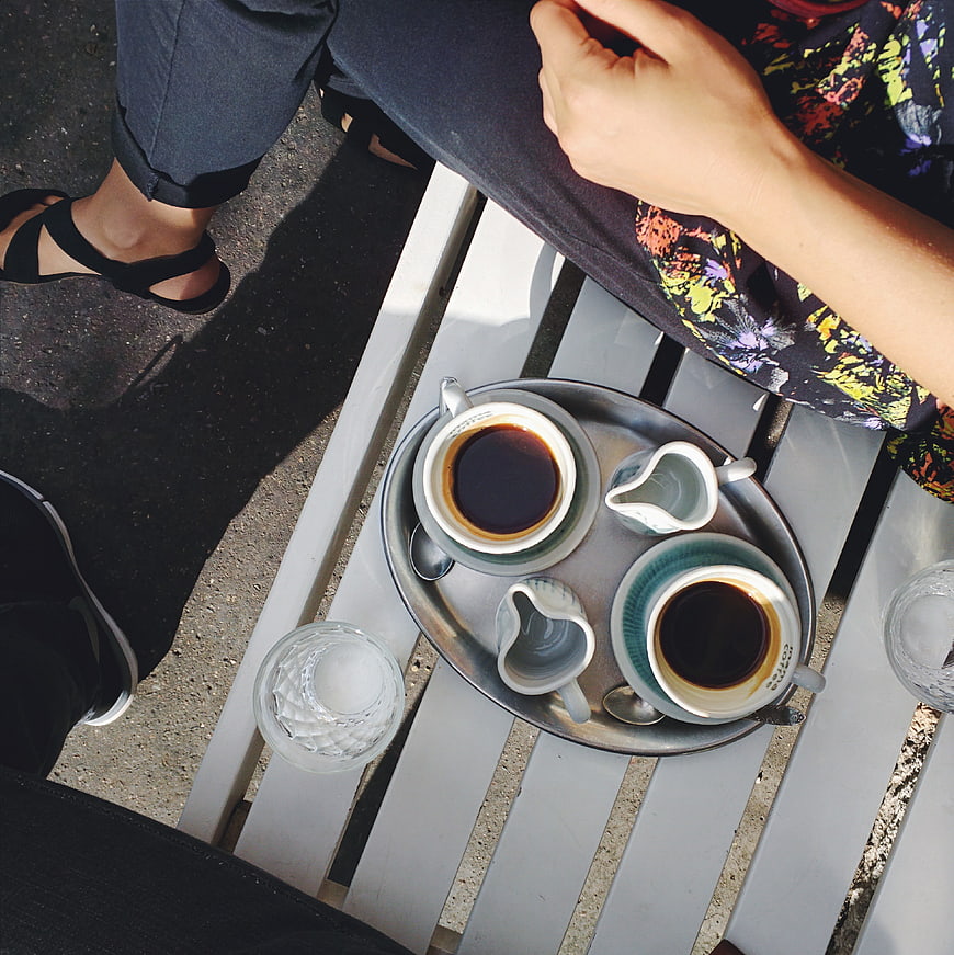 Top view of two espresso cups on a metal tray outdoors