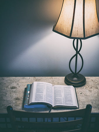Open Bible on Table with Lamp and Chair