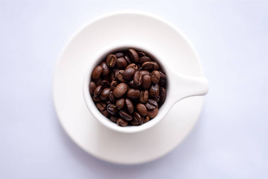 Top View of Coffee Beans in White Cup on Saucer