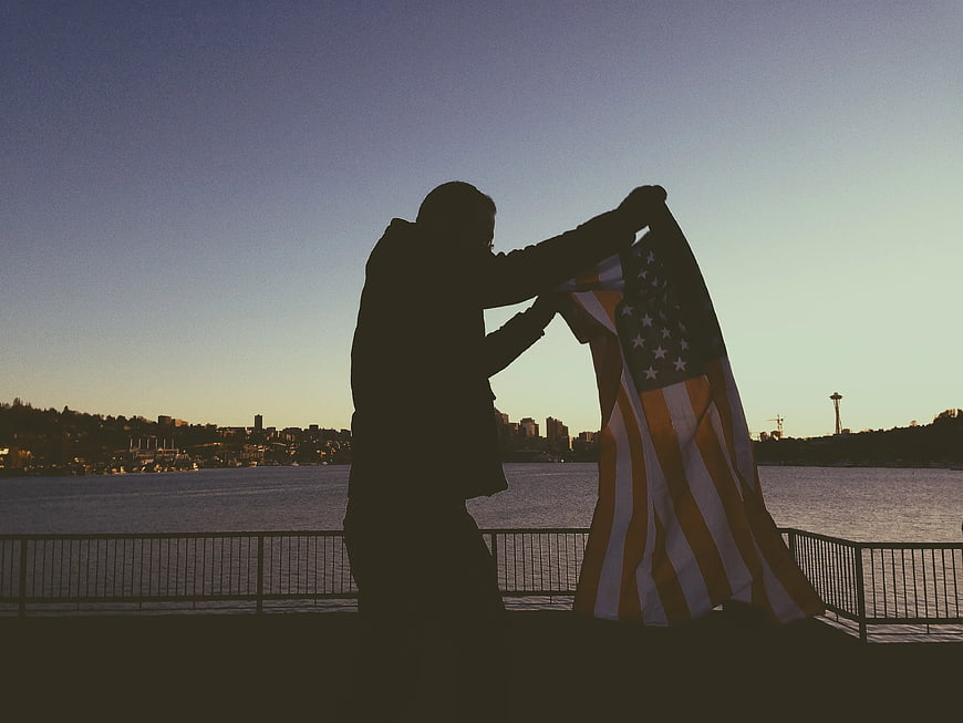 Silhouette of Man Holding American Flag at Sunset
