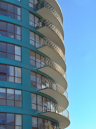 Curved Teal Apartment Building with White Balconies