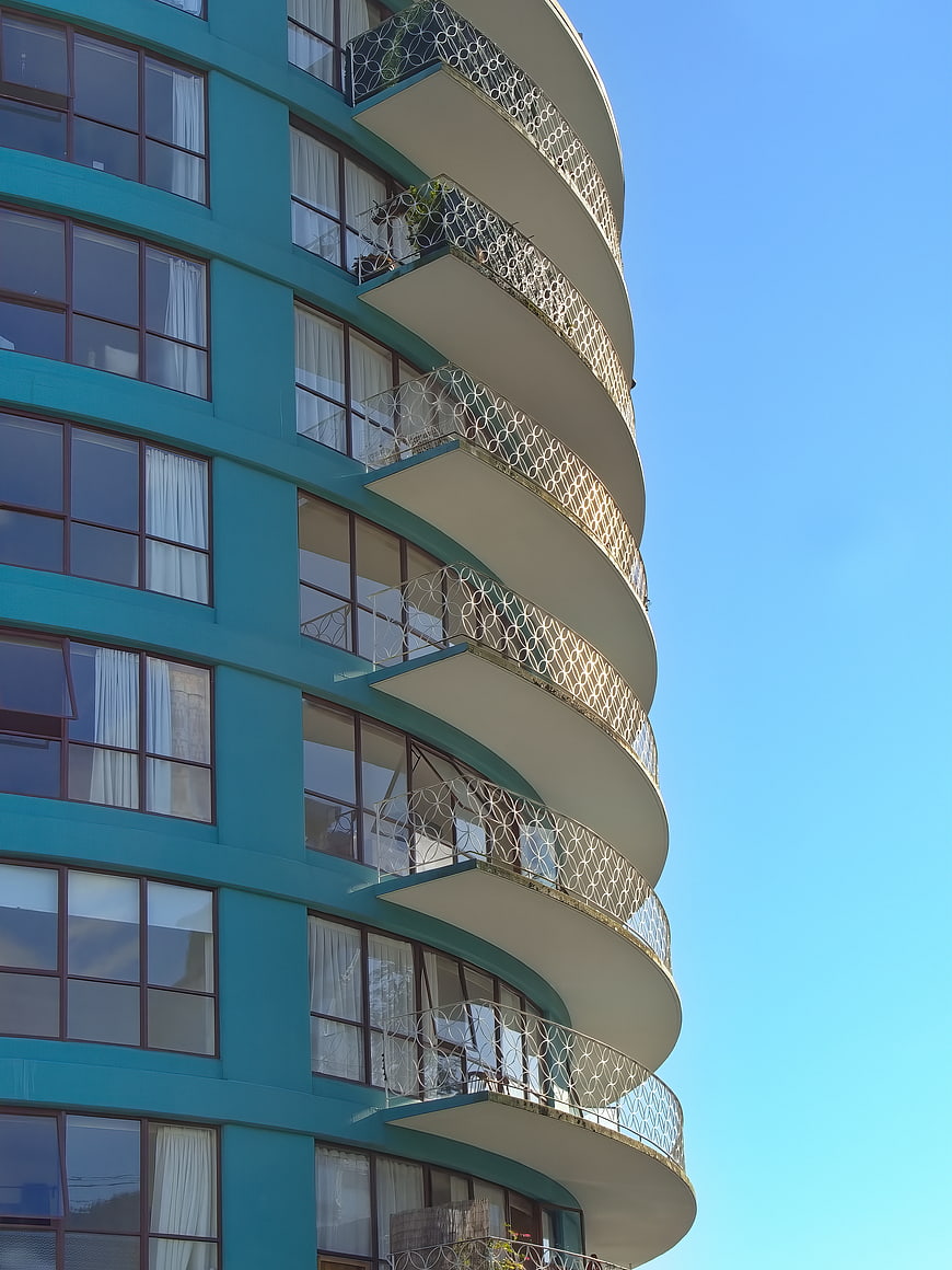 Curved Teal Apartment Building with White Balconies