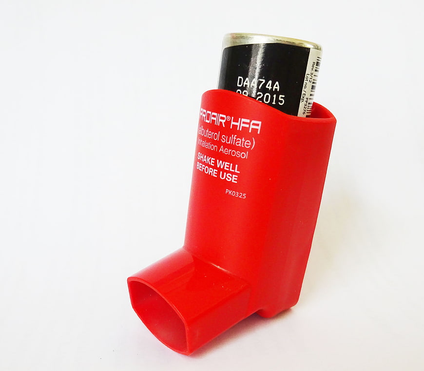 Red ProAir HFA Albuterol Inhaler With Spacer Device On White Background