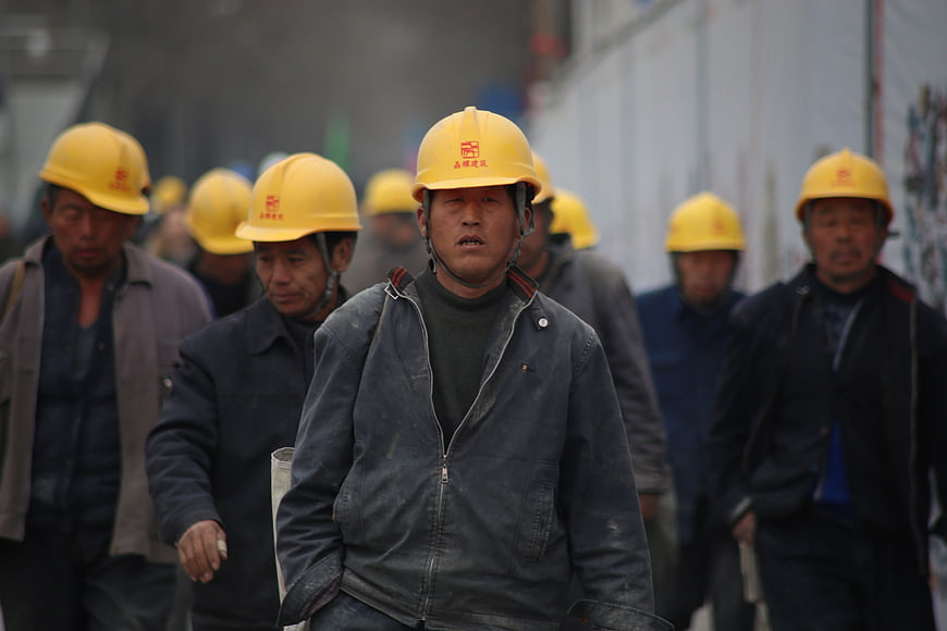 Group of construction workers in yellow hard hats walking