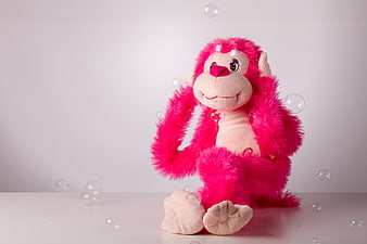Pink Plush Monkey Toy Sitting With Floating Soap Bubbles