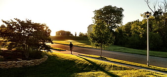 Man Walking on Suburban Street at Golden Hour