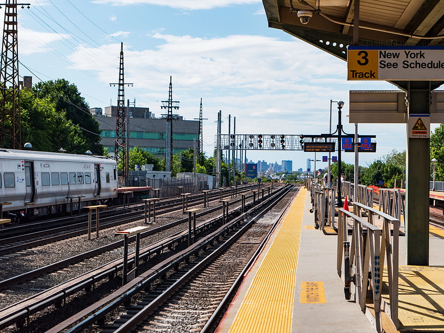 Train Station Platform with Tracks and City Skyline