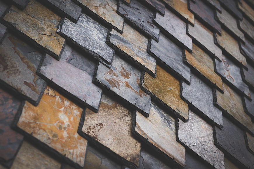 Close-up of textured slate roof tiles in earthy tones