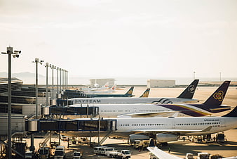 Busy Airport Tarmac with Parked Airplanes and Ground Vehicles