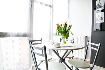 Bright dining table with tulips in modern apartment interior