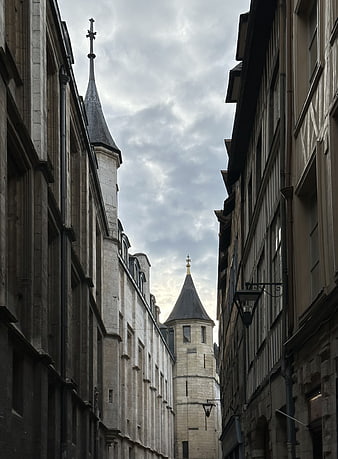 Narrow European Street with Historic Stone Buildings and Towers