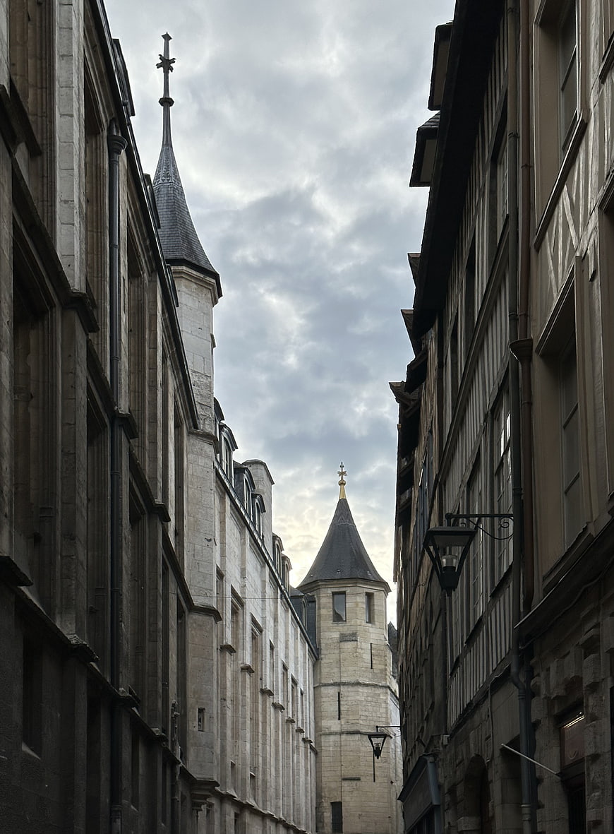 Narrow European Street with Historic Stone Buildings and Towers