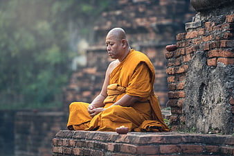 Buddhist monk meditating in ancient temple ruins