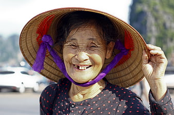 Portrait of smiling elderly Asian woman in conical hat