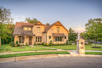 Luxury Brick Home Exterior With Landscaped Front Yard At Dusk